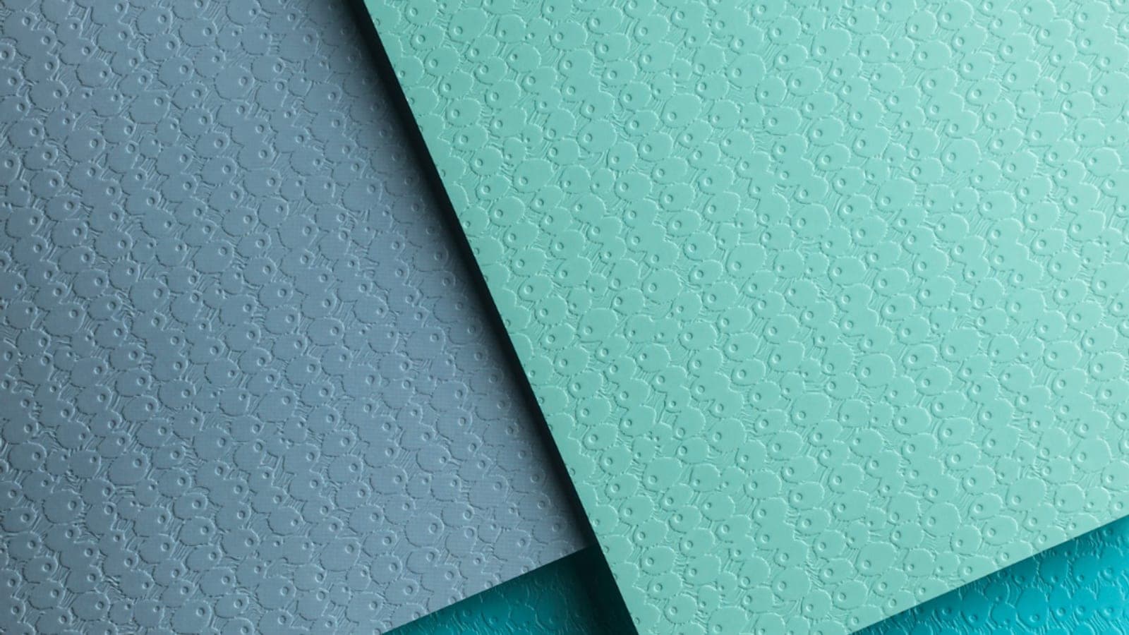 Feuilles de papier gaufré se chevauchant, dans des tons ardoise, menthe et turquoise.